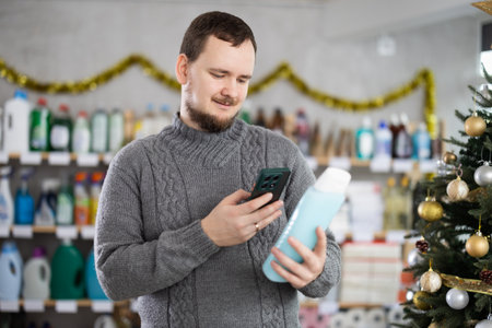 In Christmas decorated shop, man client scanning QR code on package shower gelの写真素材