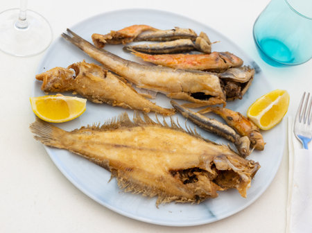 On white background, there is plate with fried fish of different varietiesの写真素材