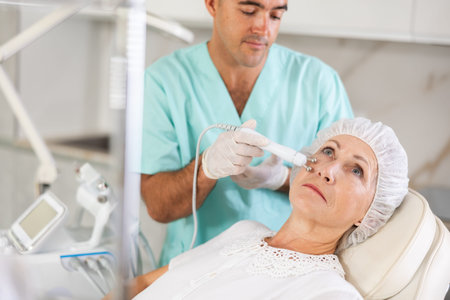 Elderly female client receiving hardware ultrasonic to revitalize and tighten facial skin at...