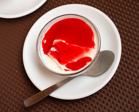 Creamy panna cotta with cranberry jam in glass bowlの写真素材