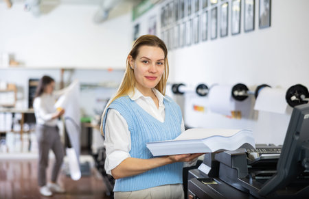 Technician operator changes paper on printer plotter machine