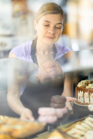 Adult woman waitress offers fresh donutsの写真素材