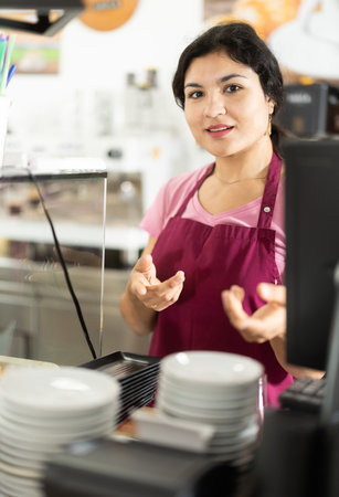 Young woman waitress places clean platesの写真素材