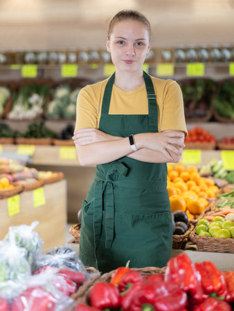 Teenage girl seller in vegetable shopの写真素材