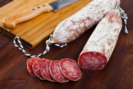 Spanish longaniza sausages cut in slices on a wooden surfaceの写真素材
