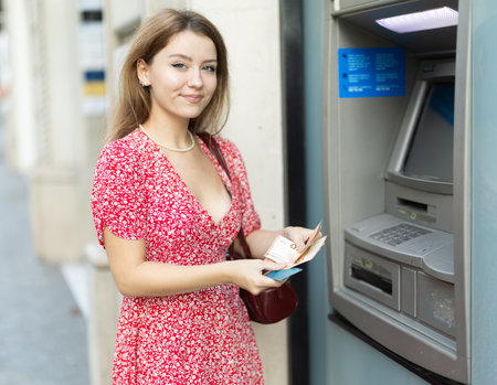 Young woman withdrawing money from an atmの写真素材
