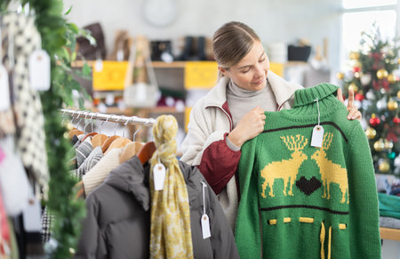 Woman choosing a reindeer sweater for Christmas and New Year