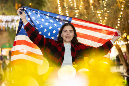 Smiling girl with flag of USA on street Christmas fairの写真素材