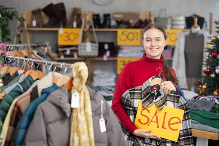 Teen girl with poster in hands announce mega discounts, presenting SALE