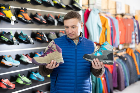 Man examine compare item of winter comfortable tracking shoesの写真素材