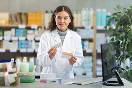 Young woman pharmacist offering pillsの写真素材