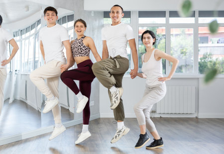 Group of girls and guys rehearsing stepdance in dance studioの写真素材
