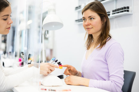 Client girl chooses a nail polish on a color paletteの写真素材