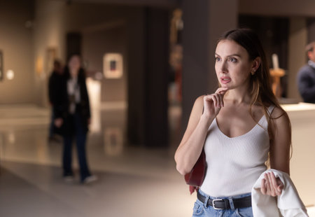 Girl view pictures and icons in museum hall