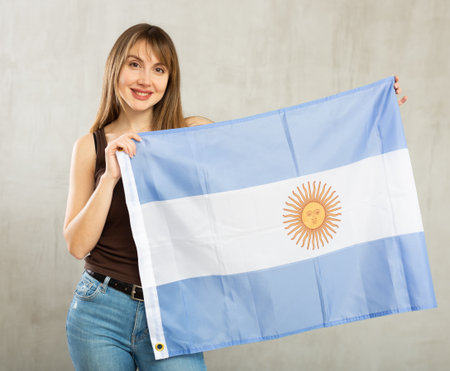 Young cheerful woman holding Argentina flagの写真素材