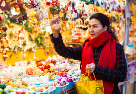 Asian female choosing decorations at Christmas fairの写真素材