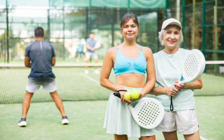 Female tennis players standing on outdoor court after gameの写真素材