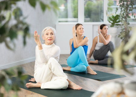 Elderly woman doing yoga in fitness studioの写真素材