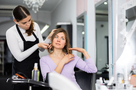 Hairdresser is discussing a haircut with a female clientの写真素材