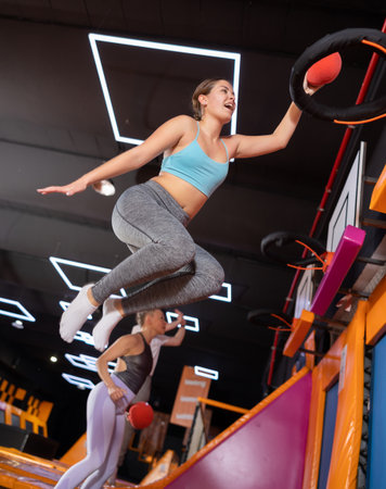 Young woman playing ball in trampoline centerの写真素材