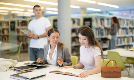 Women students study together in the libraryの写真素材