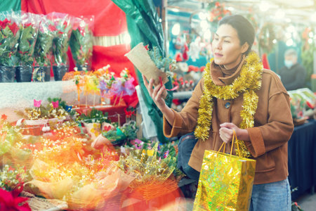 Woman choosing christmas decoration at street fairの写真素材