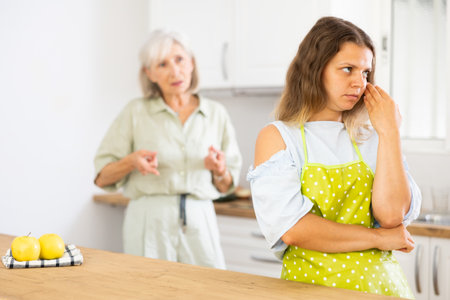 Sad woman ignoring her senior mother arguing with herの写真素材