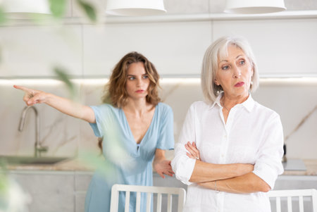 Adult woman quarreling with elderly woman in kitchenの写真素材
