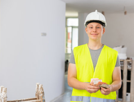 Teenage boy holding bunch of earned money for part-time workの写真素材