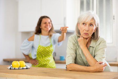 Aggrieved elderly woman having quarrel with her daughterの写真素材