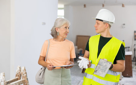 Mature woman with documentation in her hands talks with a fifteen-year-old worker