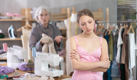 Mature dressmaker scolds assistant at workの写真素材