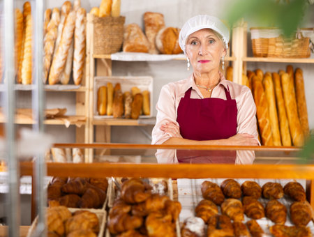 Senior female baker holds basket with finished products