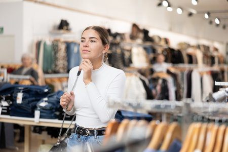 Young girl watching excitedly large stock of clothes in clothing storeの写真素材
