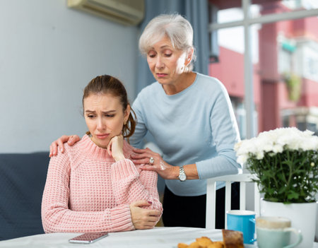 Senior mother encouraging her upset daughterの写真素材