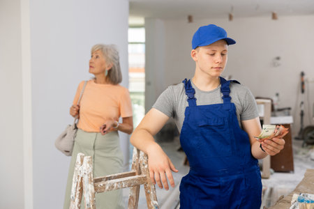 Portrait of teenage boy holding bunch of cash in construction siteの写真素材