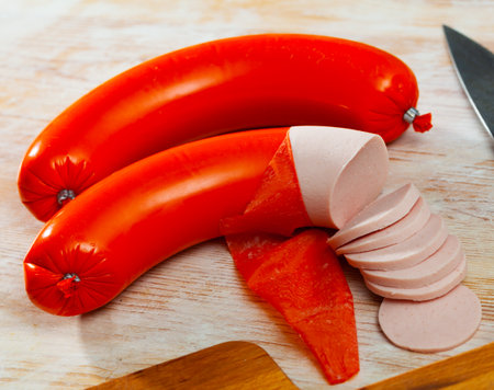 Appetizing boiled sausage mortadella on wooden tableの写真素材
