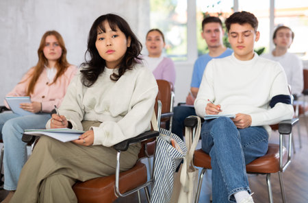 Asian girl student listening to lecture and taking notes