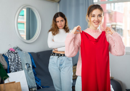 Two young women choosing clothes to wearの写真素材