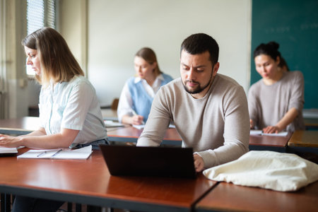 Two students studies on a laptop and writes a synopsis