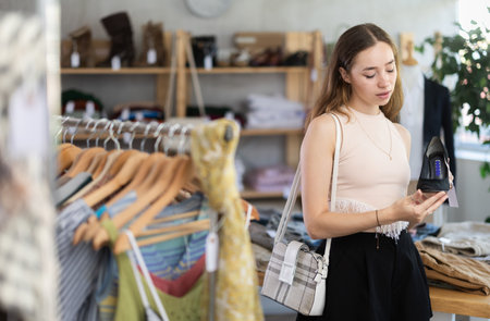 Young woman choosing heels in clothing storeの写真素材