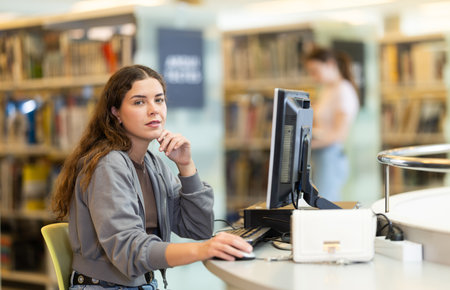 Female student working on computer in libraryの写真素材