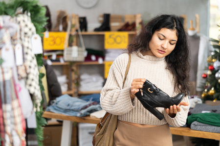 Latina chooses heeled boots on the background of a Christmas treeの写真素材