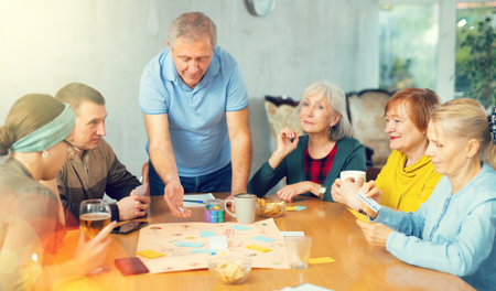 Group of positive older people playing tabletop gameの写真素材