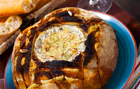 Cheese fondue from camembert in bread bowl
