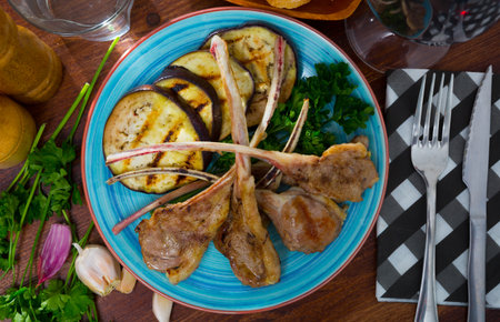 Grilled tasty lamb ribs with eggplants served at plate with greensの写真素材