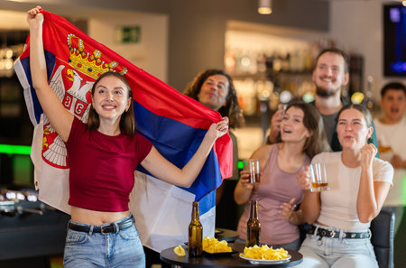 Group of fans in bar with Serbian flagの写真素材