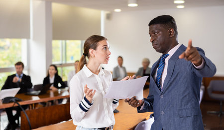 Middle aged african male boss being angry at young white female employee