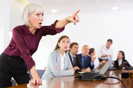 Displeased senior white female boss with her subordinateの写真素材