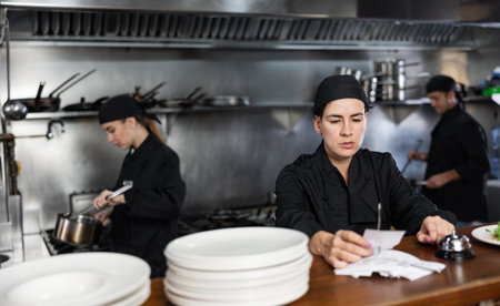 Chef checking orders and giving out mealの写真素材